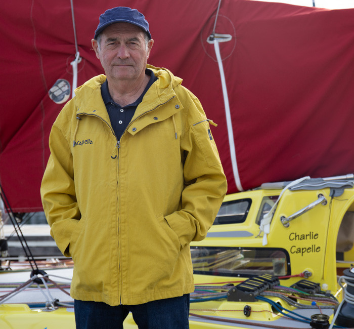 Navigateur Charlie Capelle debout sur son trimaran jaune Acapella pour Mousqueton