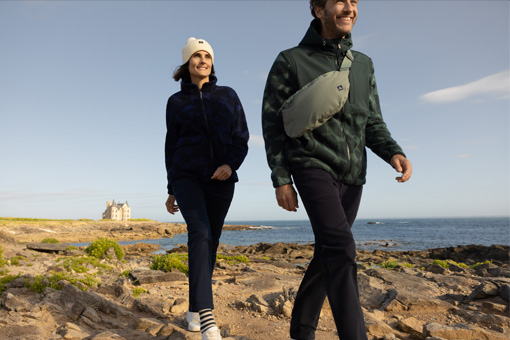 Un homme et une femme se baladant au bord de la mer en polaire Mousqueton