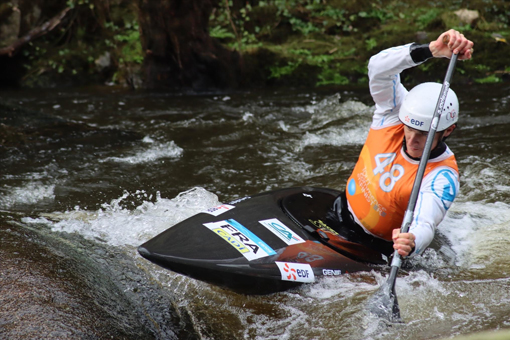 Nicolas pagaie sur la rivière avec son canoë lors d'une compétition