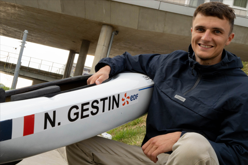 Nicolas tient son canoë où il y est inscrit N.GESTIN et sourit, il porte des vêtements Mousqueton