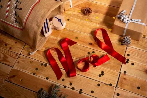 Noël écrit en ruban rouge à côté de cadeaux de Noël