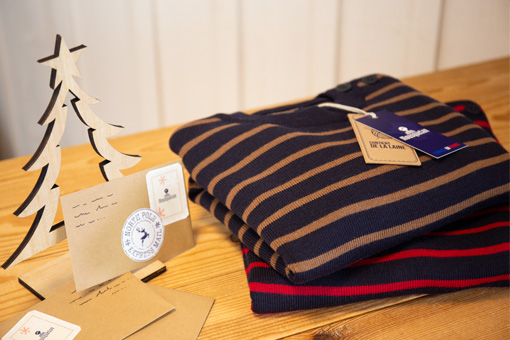 Deux pulls marins made in France pliés sur une table pour Noël