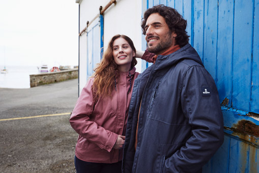 Femme portant une veste d'hiver rose et homme portant une veste d'hiver bleu marine.