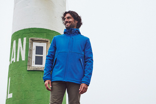 homme portant une veste softshell bleue à capuche