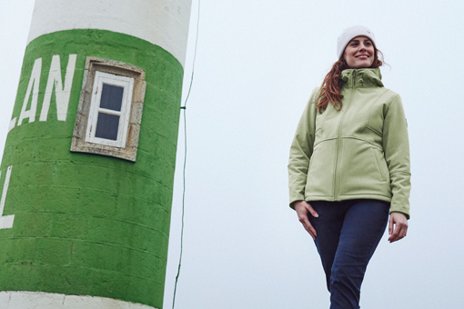 femme portant une veste polaire softshell verte avec un bonnet