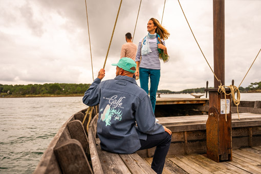 Homme portant une vareuse spéciale Semaine du Golfe et femme portant un foulard spécial Semaine du Golfe