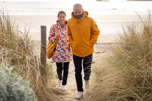 Un homme et une femme au bord de mer vestes colorées Mousqueton