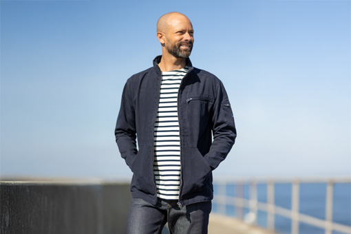 Homme portant une veste en toile bleu marine et une marinière Mousqueton