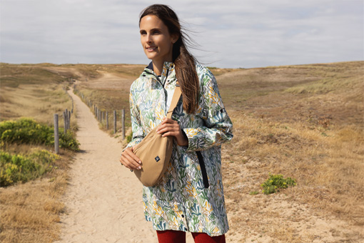Un homme et une femme sur un sentier en bord de mer portant un ciré imprimé Mousqueton