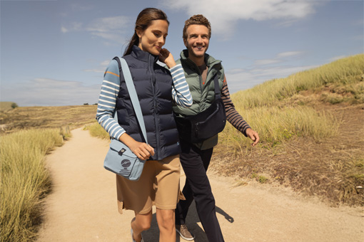 Un homme et une femme qui se baladent au bord de mer habillés en collection d'automne Mousqueton