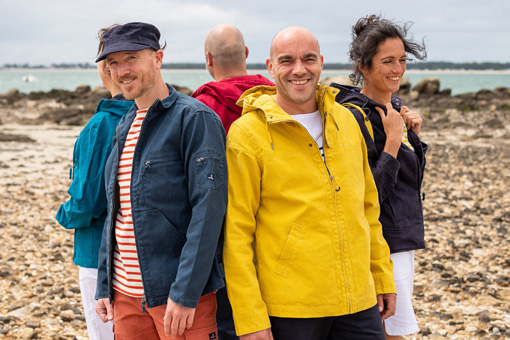 Un groupe d'ami sur la plage portant des vestes en toile Mousqueton