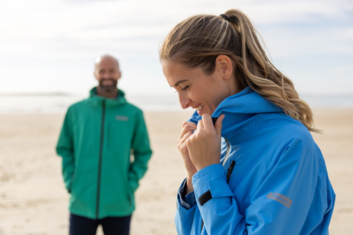 Un homme et une femme en veste imperméable Mousqueton sur une plage