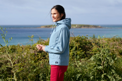 Femme portant une veste Fiona de la marque Mousqueton marchant en bord de mer