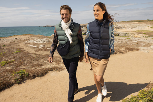 Un homme et une femme en doudounes mi-saison au bord de mer